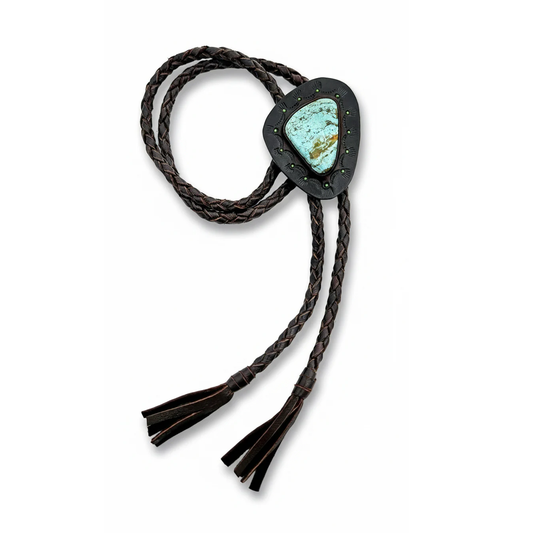 Handmade Fox turquoise bolo tie by Kelly Horrigan featuring a natural pale blue turquoise stone, black hand-tooled leather setting, dark braided deerskin cord, and leather tassels.