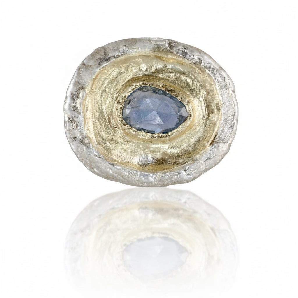 One-of-a-kind Fragmented Ring III by Alexis Pavlantos, featuring a 1.05ct pear-shaped rose-cut blue sapphire surrounded by sculptural recycled 14k yellow gold and textured sterling silver.