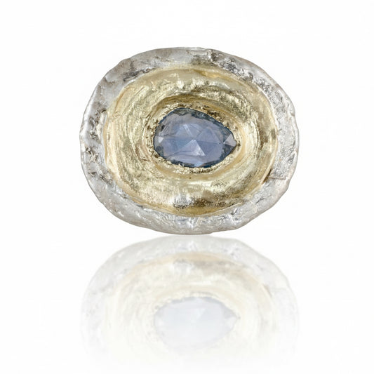 One-of-a-kind Fragmented Ring III by Alexis Pavlantos, featuring a 1.05ct pear-shaped rose-cut blue sapphire surrounded by sculptural recycled 14k yellow gold and textured sterling silver.