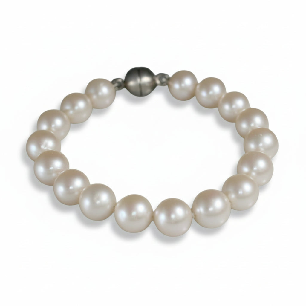 Handmade freshwater pearl bracelet by Kiki Pavlantos, featuring luminous white round pearls and a sterling silver magnetic ball clasp.
