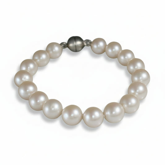 Handmade freshwater pearl bracelet by Kiki Pavlantos, featuring luminous white round pearls and a sterling silver magnetic ball clasp.