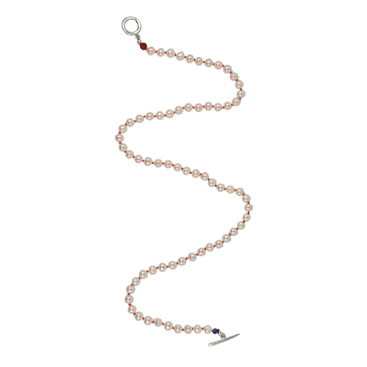 Freshwater pearl necklace hand-knotted on coral silk with a sterling silver toggle clasp and lapis beads, arranged on a white background.