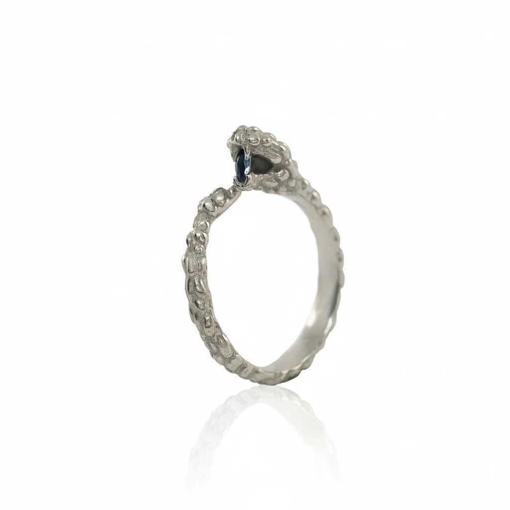 Ichos Snake Ring in recycled 14k white gold featuring a sculptural snake design, textured band, and natural sapphire gemstone.
