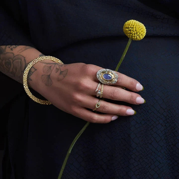 Sculptural Ichos Snake Ring by Alexis Pavlantos styled on the hand with other fine jewelry, showcasing its bold serpent-inspired design.