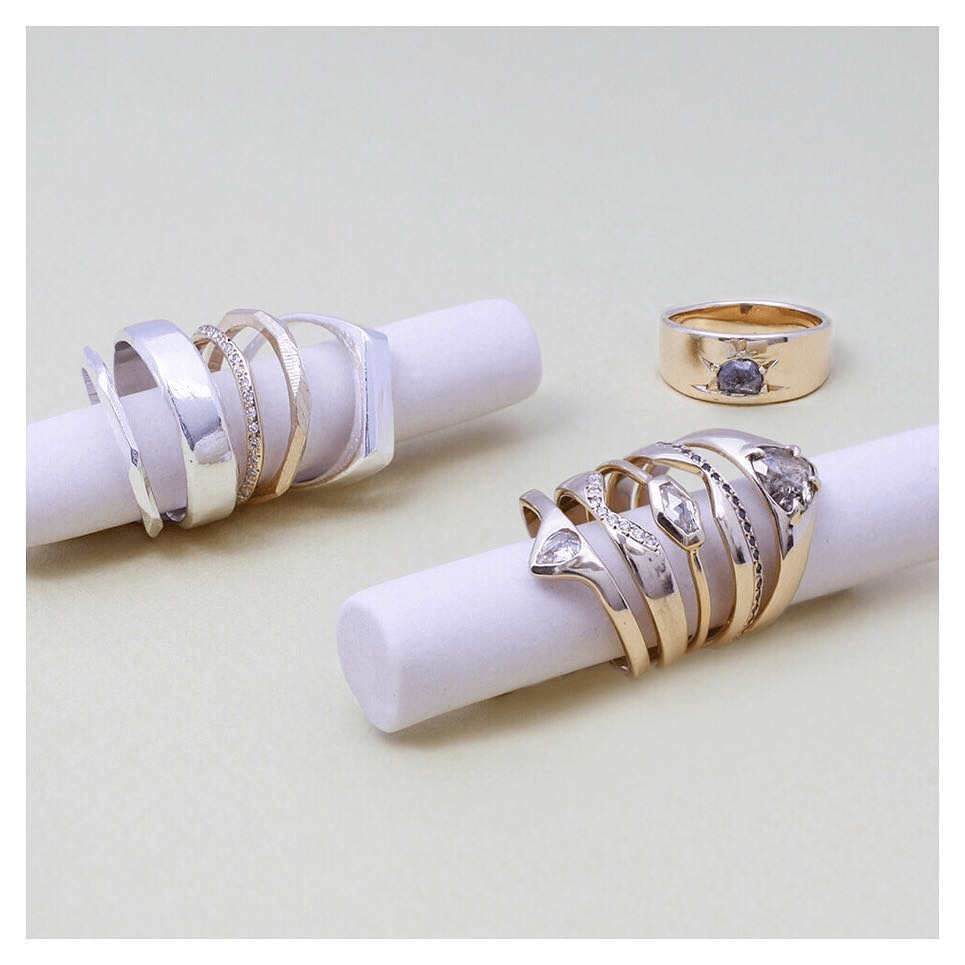 Assorted Adeline Jewelry rings arranged in a styled stack on a white background