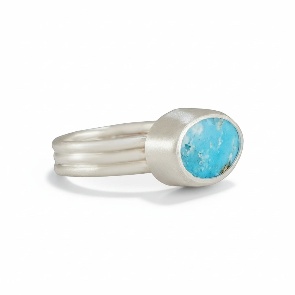 Silver ring with a turquoise stone on a white background