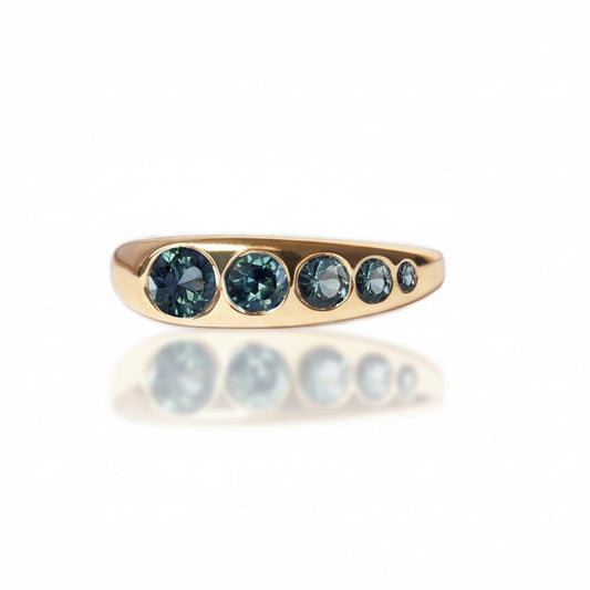 Lila Suprima Ring by M. Hisae featuring five teal-blue Montana sapphires flush-set in a handcrafted 14k yellow gold band.