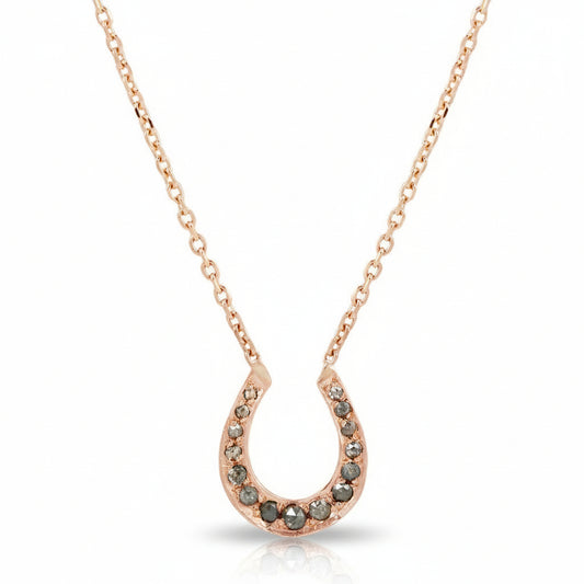 14k rose gold horseshoe necklace by Amanda George featuring salt and pepper diamonds set along a delicate horseshoe pendant on an 18-inch gold chain.