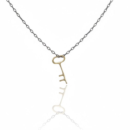 Medium Golden Key Necklace by Luana Coonen, featuring a handcrafted 14k yellow gold key pendant on an oxidized sterling silver chain.