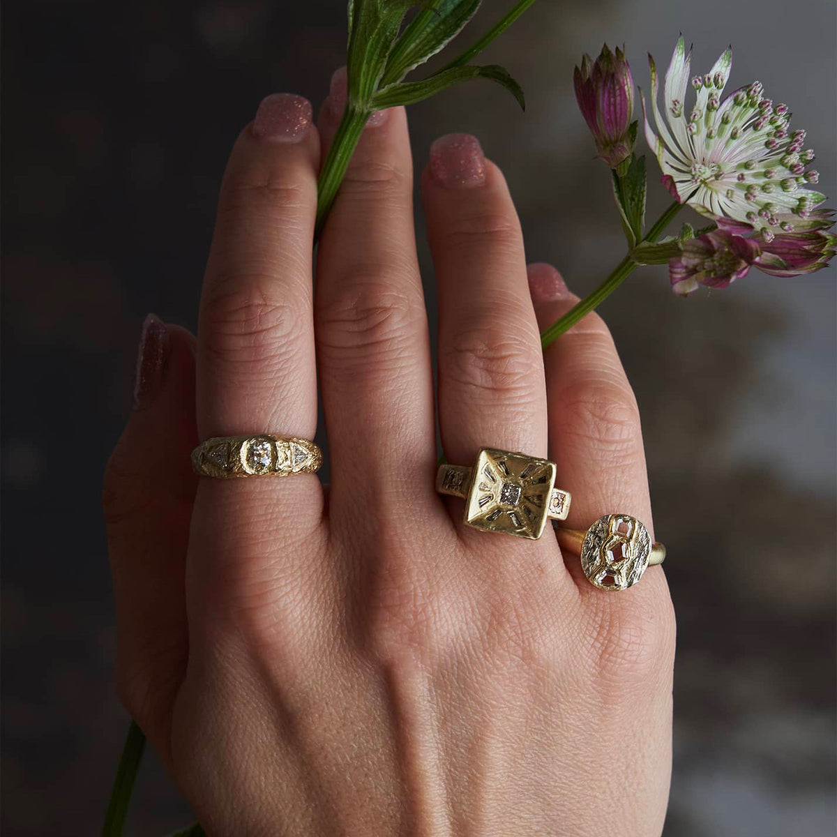 Mesa Diamond Ring worn on a hand alongside sculptural gold rings, showcasing its bold geometric design and substantial gold setting.