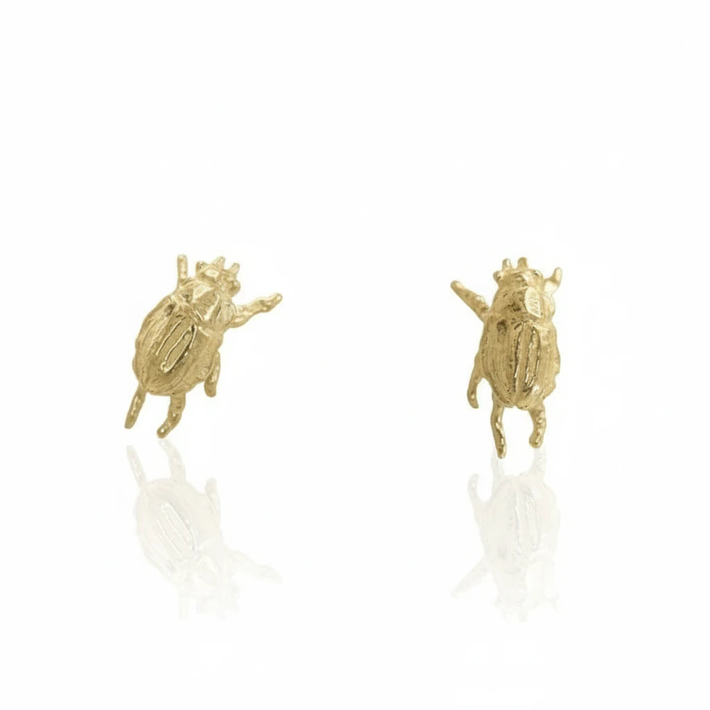 Pair of handcrafted Micro Beetle Stud Earrings in recycled 14k yellow gold by Alexis Pavlantos, featuring miniature sculptural beetles with intricate details.