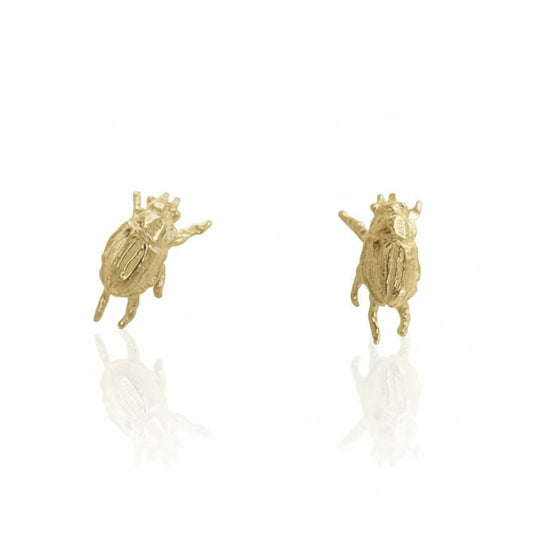 Pair of handcrafted Micro Beetle Stud Earrings in recycled 14k yellow gold by Alexis Pavlantos, featuring miniature sculptural beetles with intricate details.