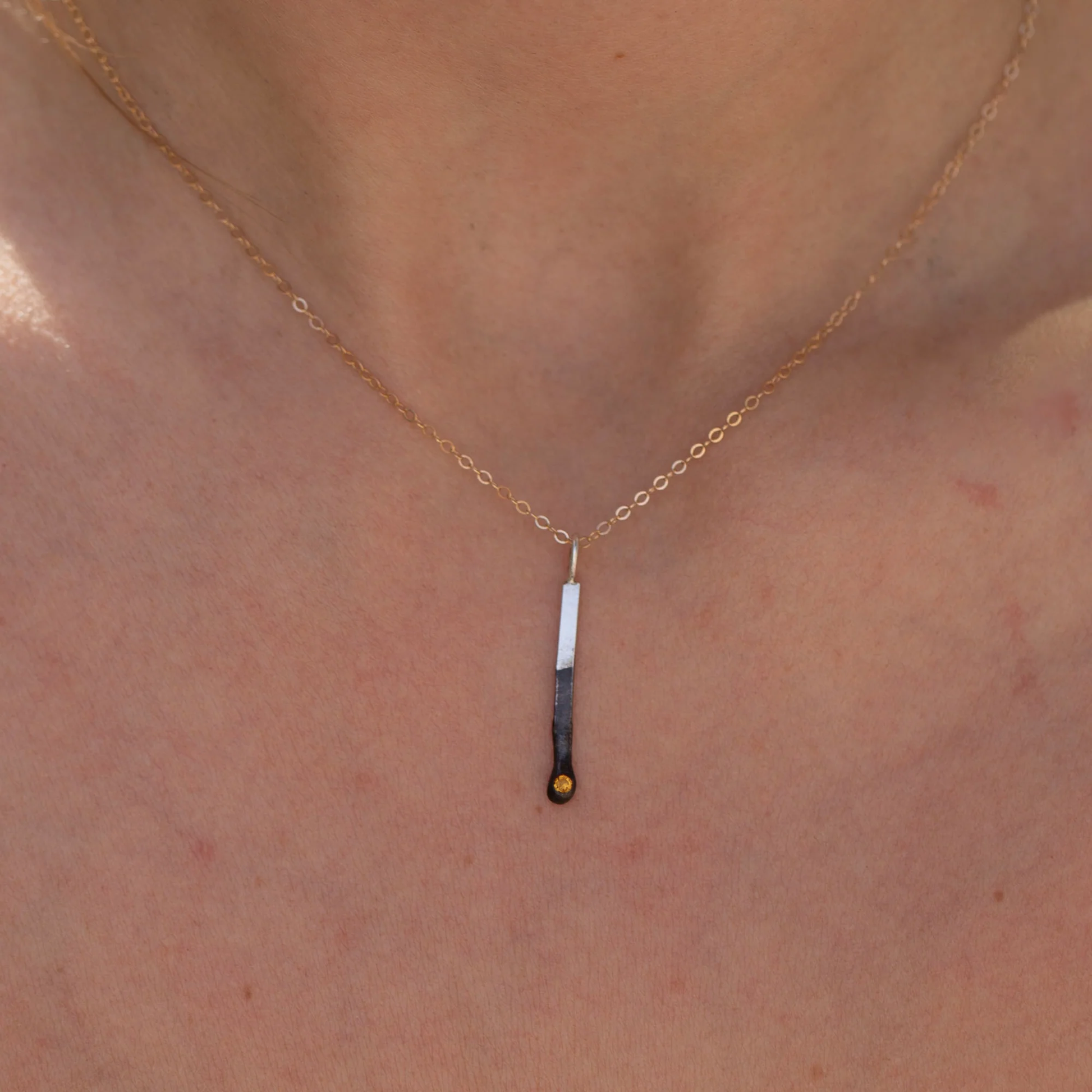 Sterling silver mini match charm with citrine shown on model neckline