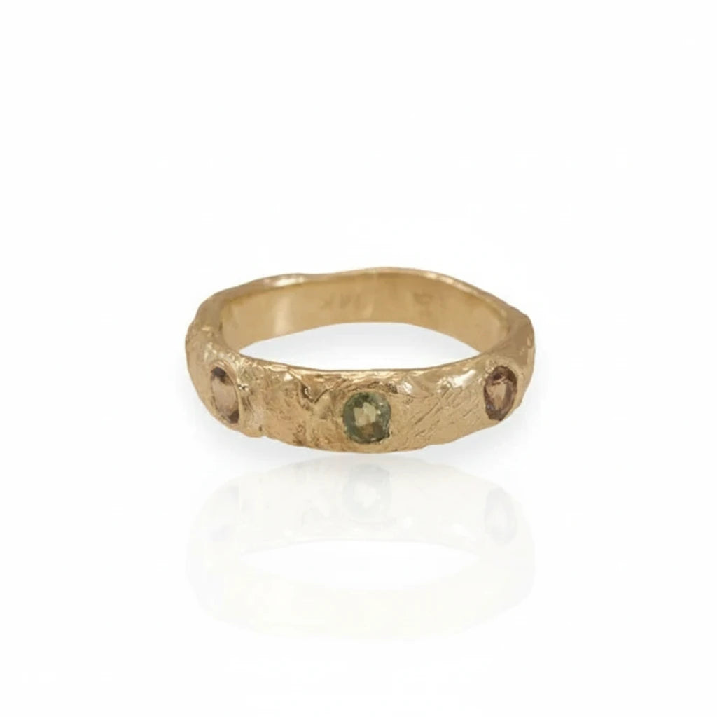 Front view of a textured 14k yellow gold stacking ring featuring repurposed oval sapphires in green and blue tones.