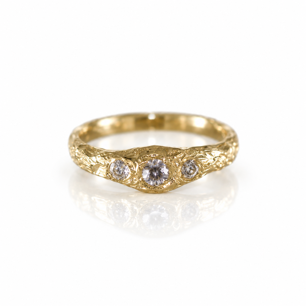 Full front view of the Monolithic Diamond Ring showing three natural old mine cut diamonds set across a richly textured 14k yellow gold band.