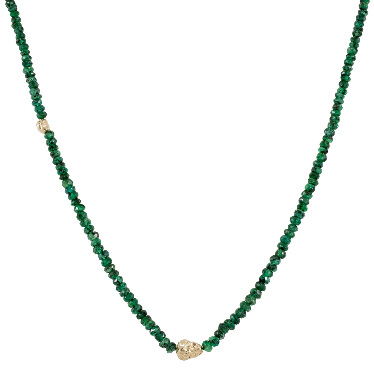 Close-up of a handcrafted natural emerald beaded necklace by Alexis Pavlantos, featuring faceted green emeralds and a sculptural 14k yellow gold rock bead centerpiece.