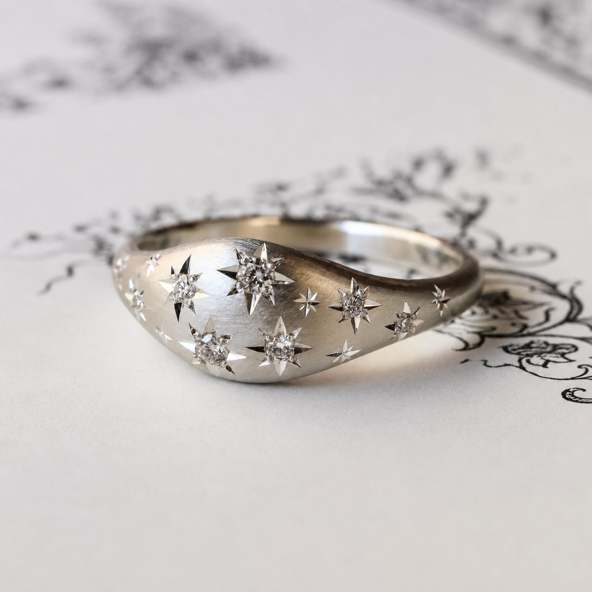 Angled view of the sterling silver Night Sky Ring, showing its gently tapered band, hand-engraved stars, and natural Canadian diamonds.