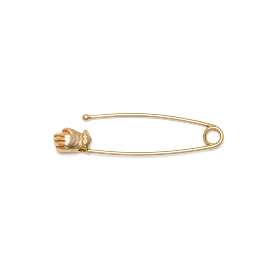 Hand Safety Pin by Oxbow in solid 14k yellow gold, featuring a slender safety pin with a miniature sculpted hand holding the pin head.