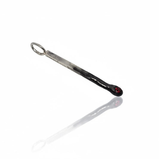 Mini Match Charm 36mm by Oxbow in sterling silver, shown diagonally with oxidized detailing, an oval bail and a dark red garnet tip.