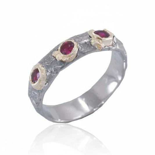 Pebbly Ring by Alexis Pavlantos featuring three Burma rubies set in textured 14k yellow gold pebble settings on a sculptural 14k white gold band.