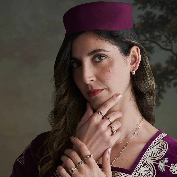 Model wearing the Pebbly Ring with Burma rubies and mixed 14k gold, styled with handcrafted jewelry in an editorial portrait.