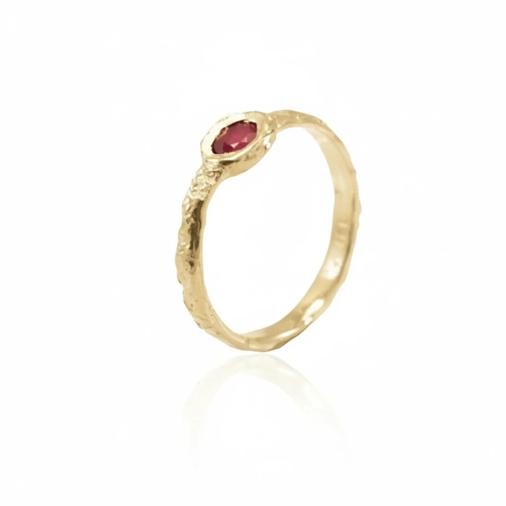 Angled view of the Petite Ruby Petra Ring showing its natural red ruby and sculptural 14k yellow gold band.