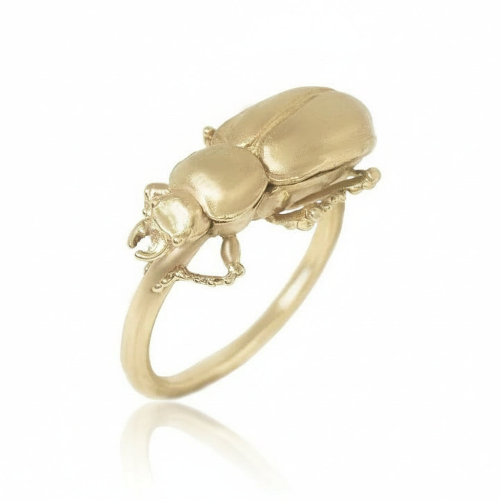 Angled view of the Pinacate Beetle Ring in recycled 14k yellow gold, featuring a hand-carved sculptural beetle resting on a delicate gold band.
