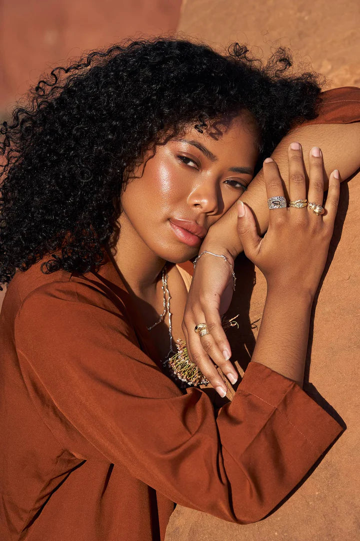 Editorial photograph of a model wearing the handcrafted Pinacate Beetle Ring, styled with other jewelry for a contemporary look.