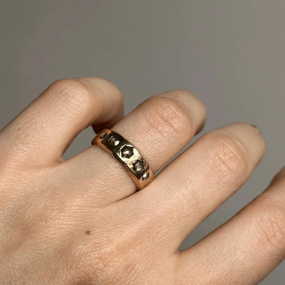 14k yellow gold Quintet Ring with hexagon salt and pepper diamonds worn on a hand in natural light.