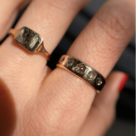 14k yellow gold Quintet Ring with hexagon salt and pepper diamonds worn on a hand in natural light.