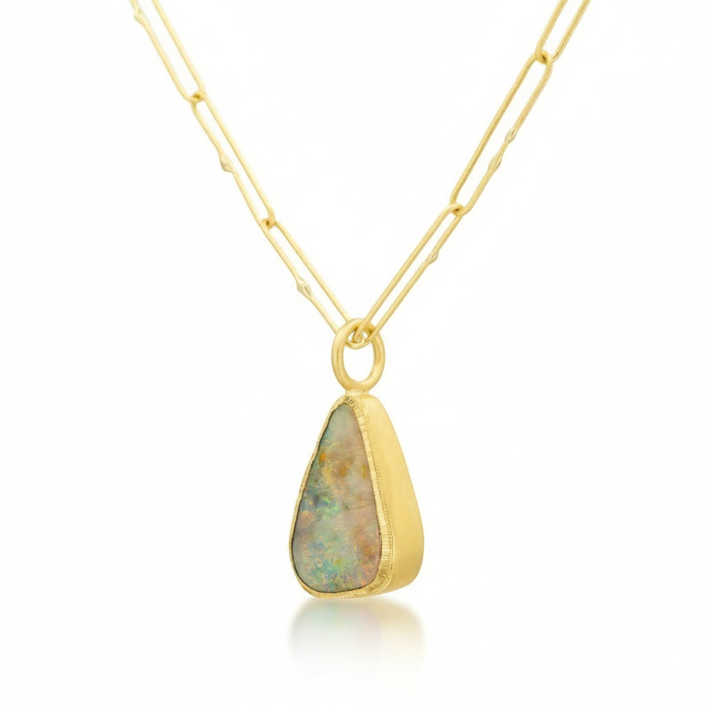 Angled view of the Rainbow Opal pendant in 18k yellow gold highlighting its pastel hues.