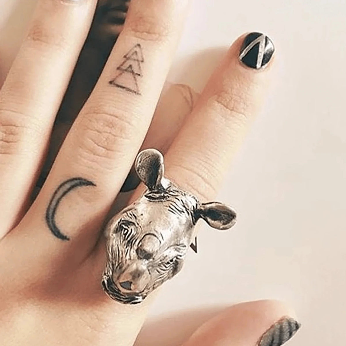 Rhino Ring worn on a model's finger, showcasing its bold sculptural rhinoceros design, sterling silver finish, and turquoise and diamond accents.