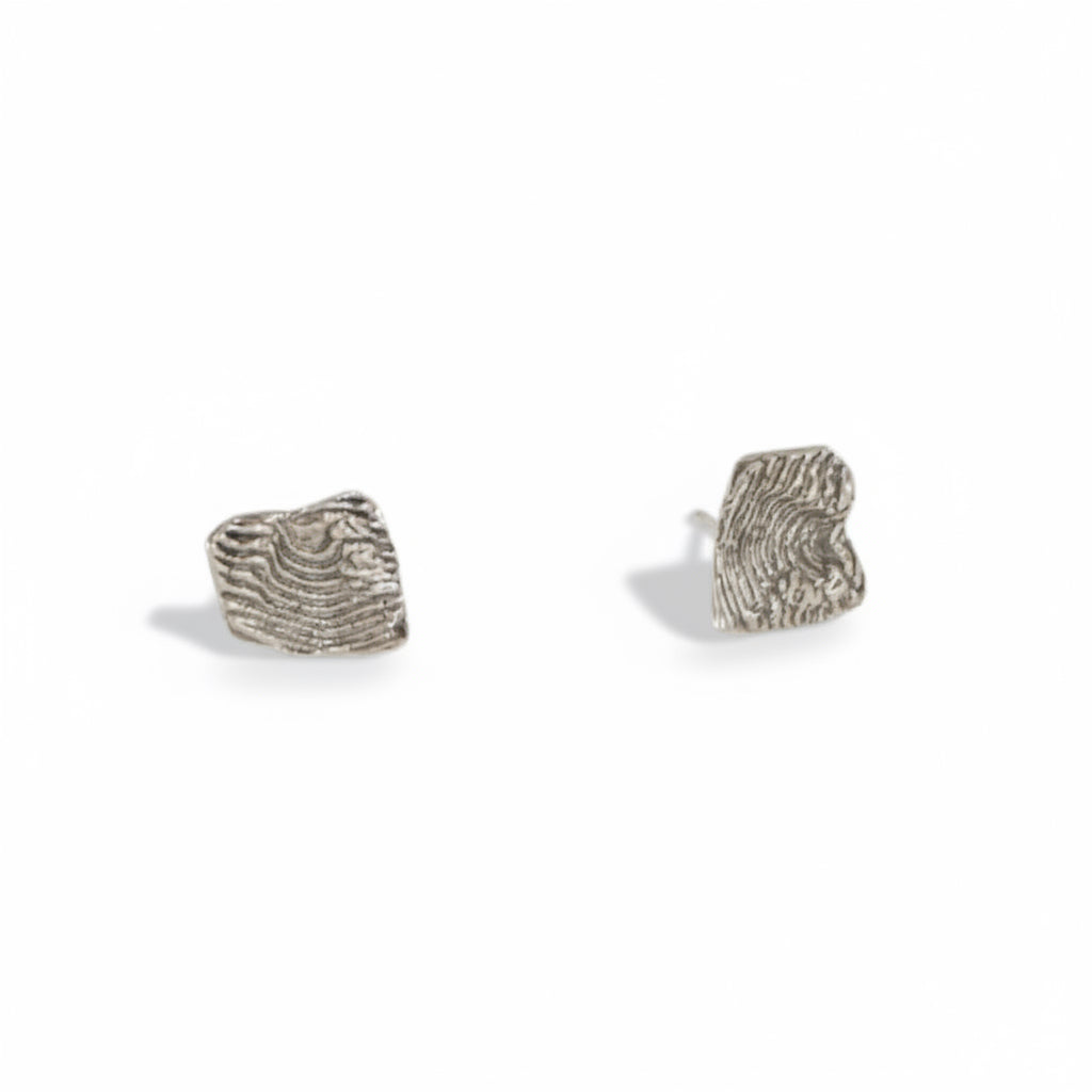 Hand-sculpted sterling silver stud earrings by Alissa Bailey featuring rugged textures inspired by New Mexico's Sandia Mountains.