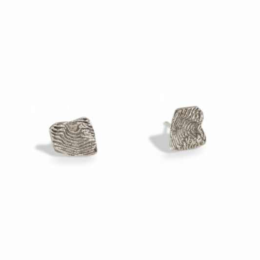 Hand-sculpted sterling silver stud earrings by Alissa Bailey featuring rugged textures inspired by New Mexico's Sandia Mountains.