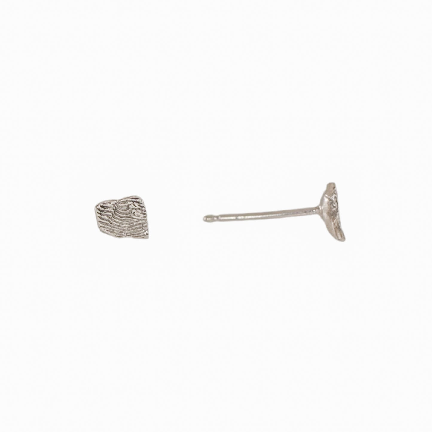 Side view of a sterling silver Sandia Fragmented stud earring showing the sculpted fragment texture and post.