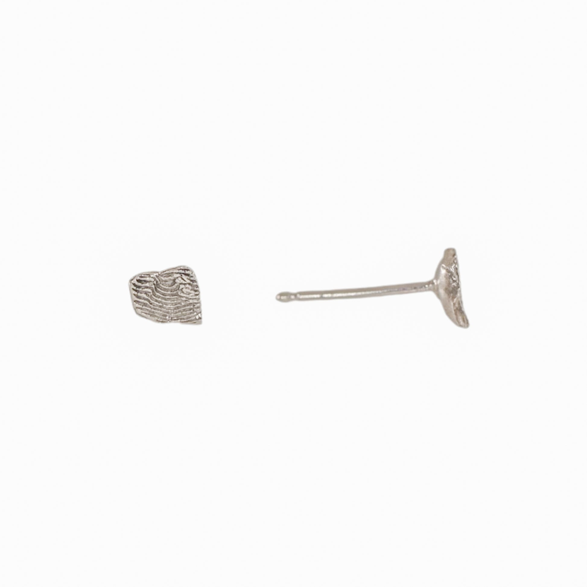 Side view of a sterling silver Sandia Fragmented stud earring showing the sculpted fragment texture and post.
