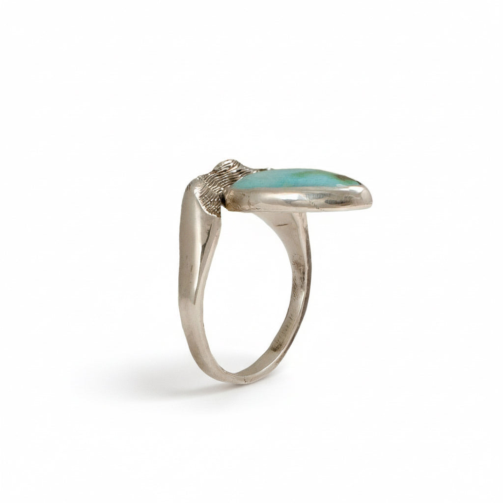 Side view of the Sandia Hug sterling silver ring showing the raised sculptural band and turquoise stone.