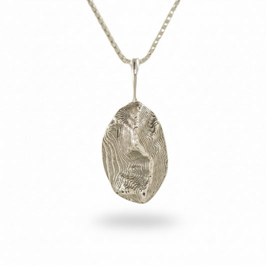 Sterling silver Sandia Mountain oval pendant with textured landscape design on a simple chain.