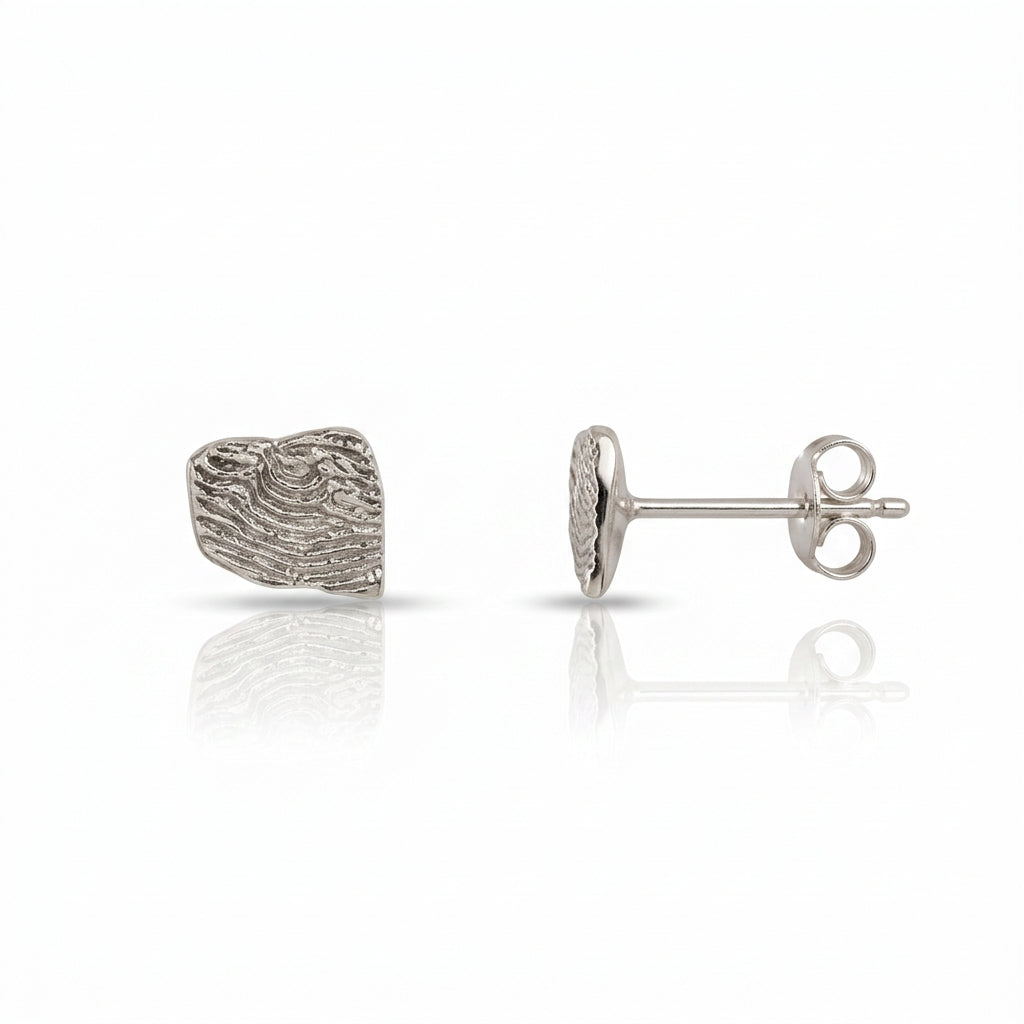 Side view of a sterling silver Sandia Fragmented stud earring showing the sculpted fragment texture and post.