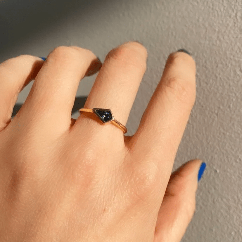 18k yellow gold Sapphire Kite Ring with a deep blue kite-shaped sapphire worn on a hand in natural light.