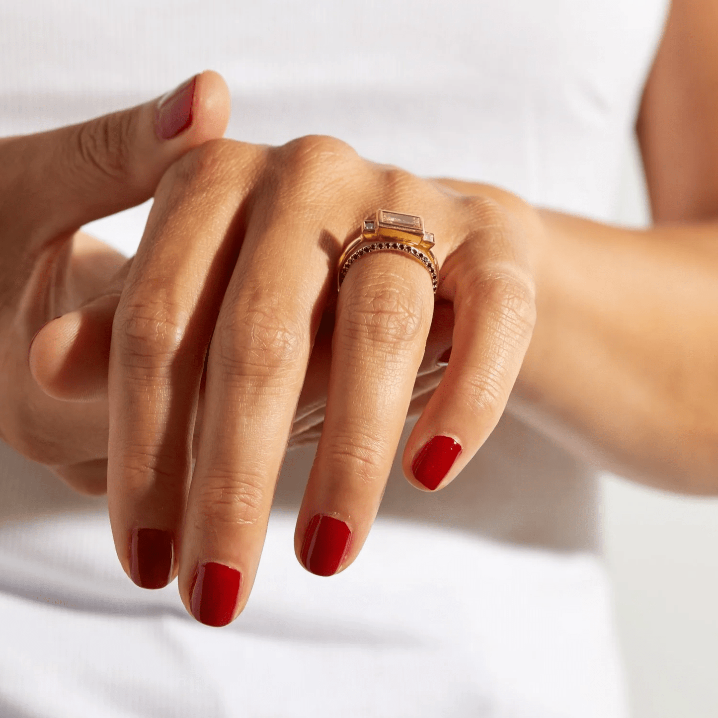 14k yellow gold Saturn Ring with black diamonds worn on a hand in natural light.