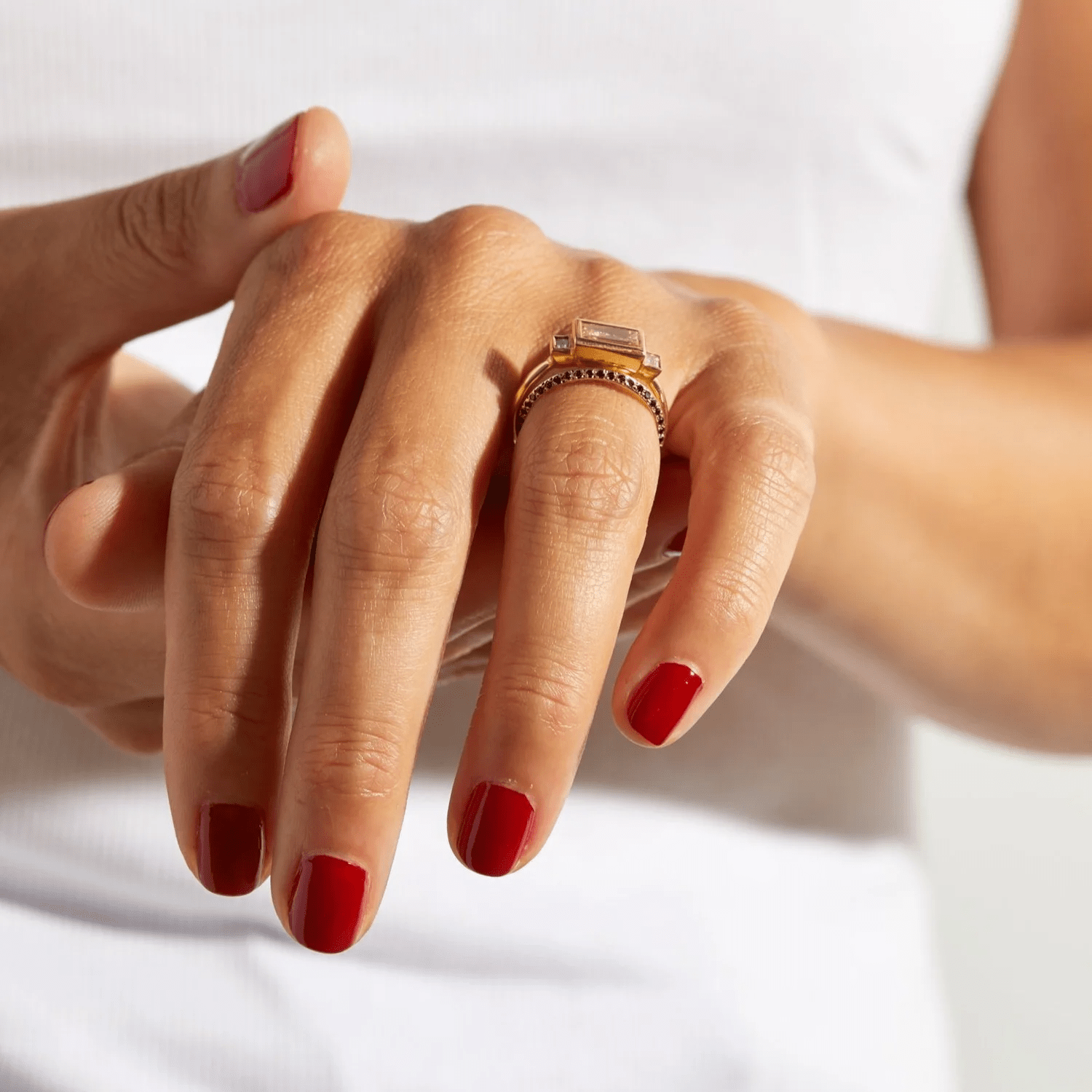 14k yellow gold Saturn Ring with black diamonds worn on a hand in natural light.
