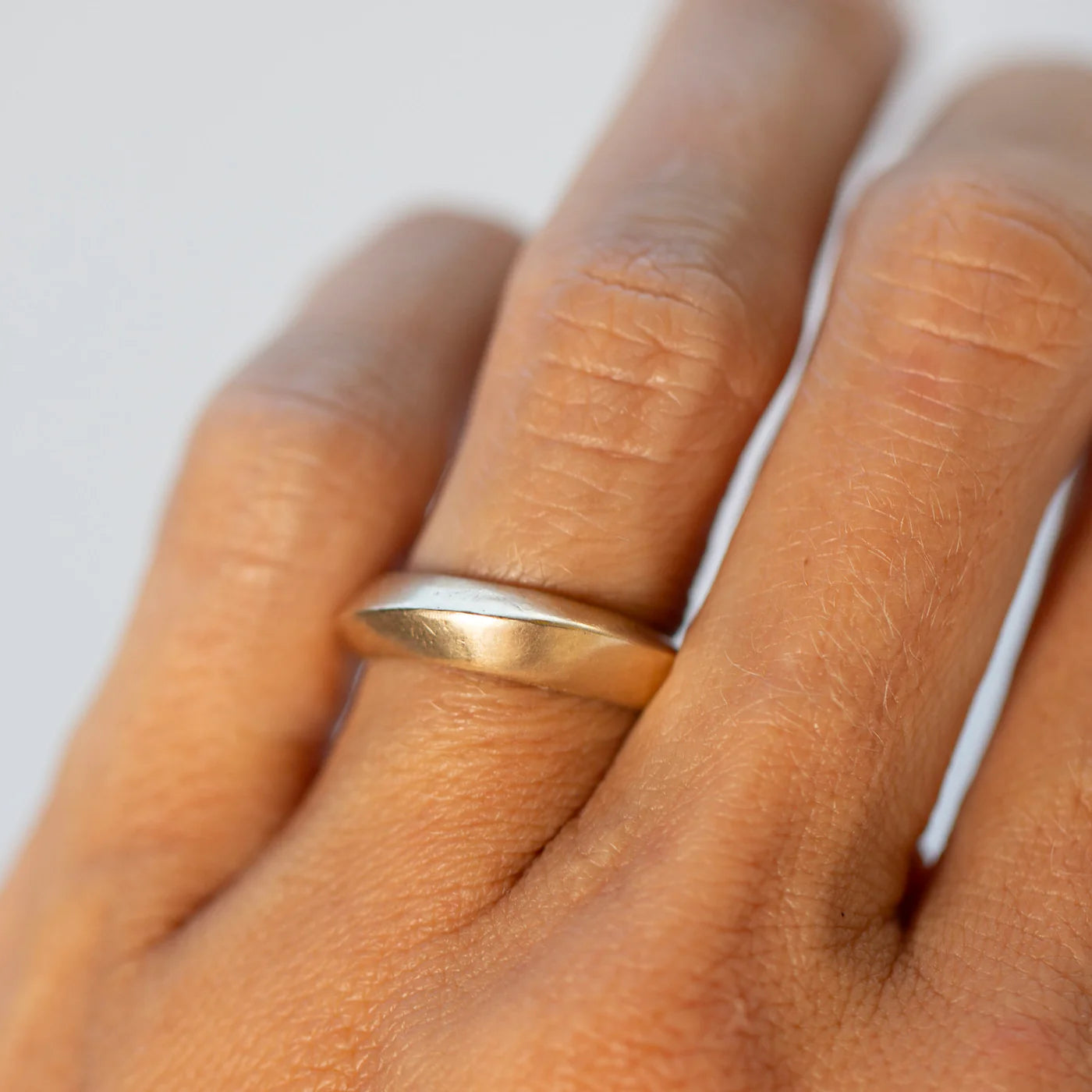 Sculptural 14k gold saucer ring stacked on the hand for a modern minimalist look