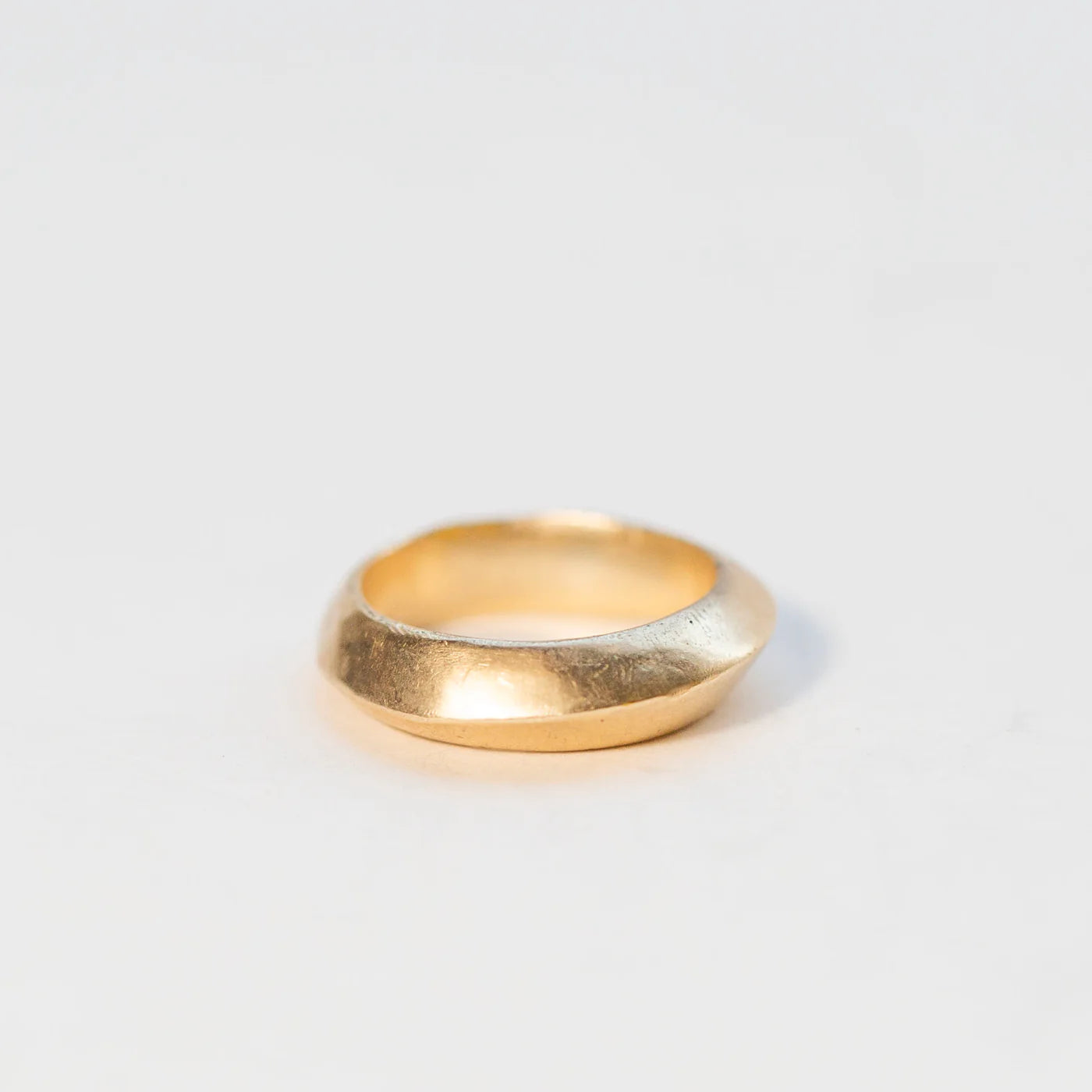 Minimal 14k gold saucer ring shown at a side angle with soft curved profile