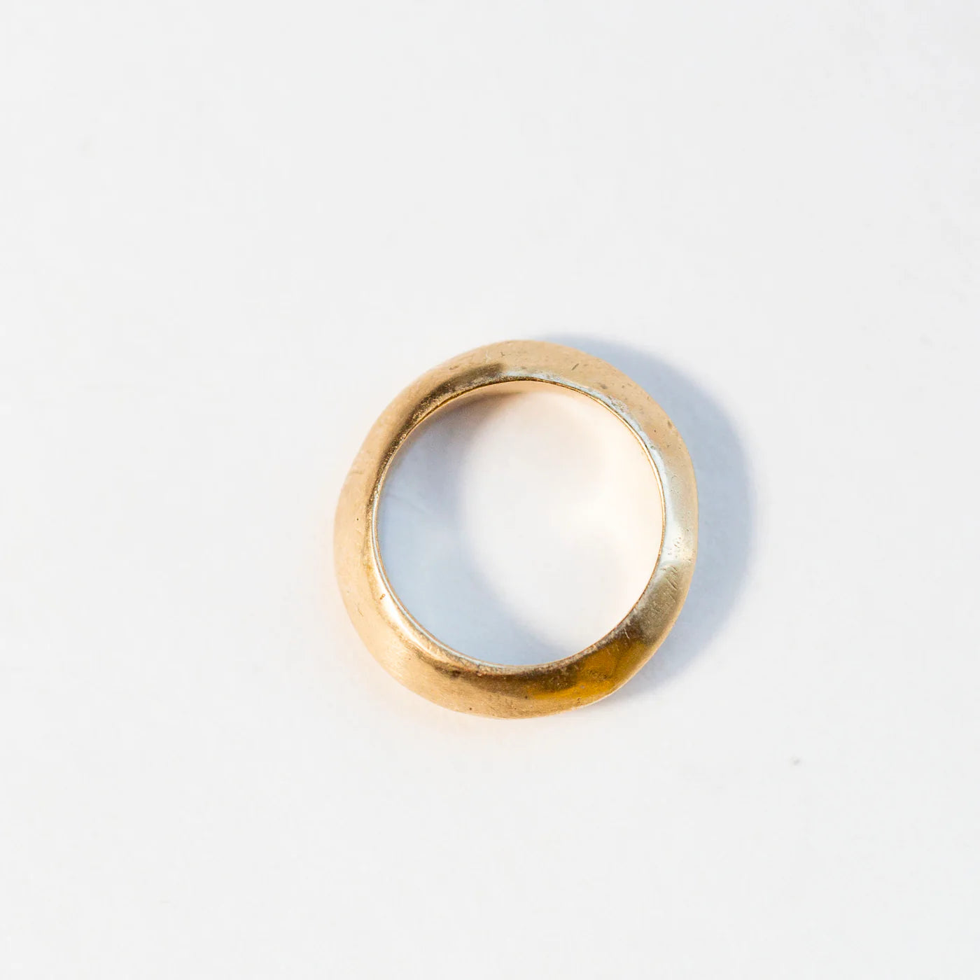 Gold saucer ring photographed in studio on a white background