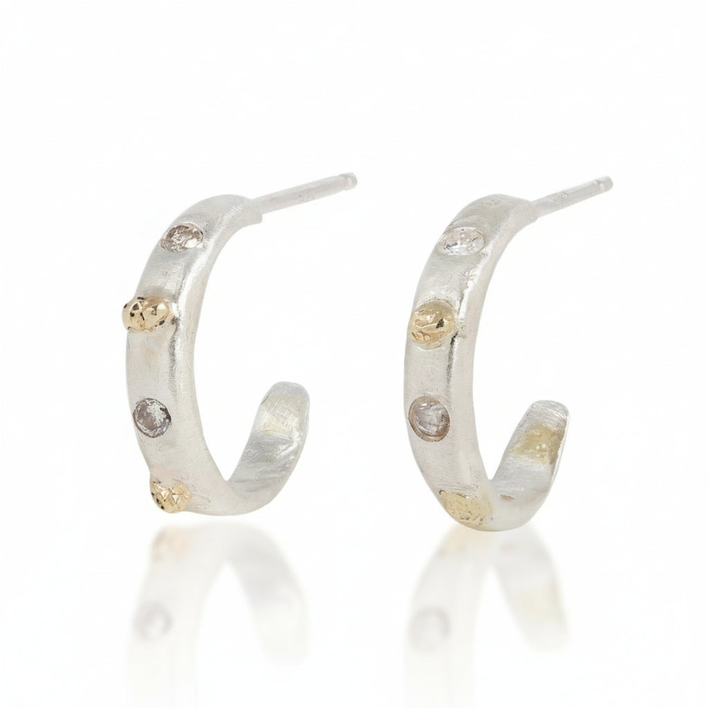 Pair of handcrafted sterling silver hoop earrings with textured 14k yellow gold accents and three recycled diamonds per earring by Alexis Pavlantos.