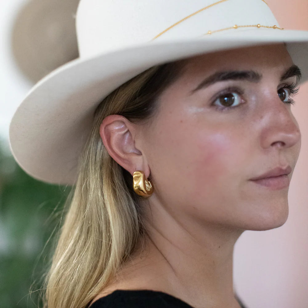 Side profile of model wearing Serrano Hoops in 14k gold, modern sculptural hoop earrings.
