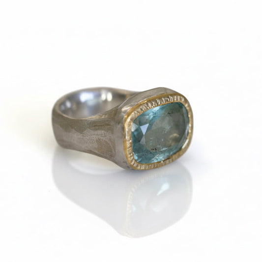 Aquamarine Shine Ring by Shaya Durbin featuring a faceted pale blue aquamarine gemstone set in a 22k yellow gold bezel on a sculptural recycled sterling silver band.