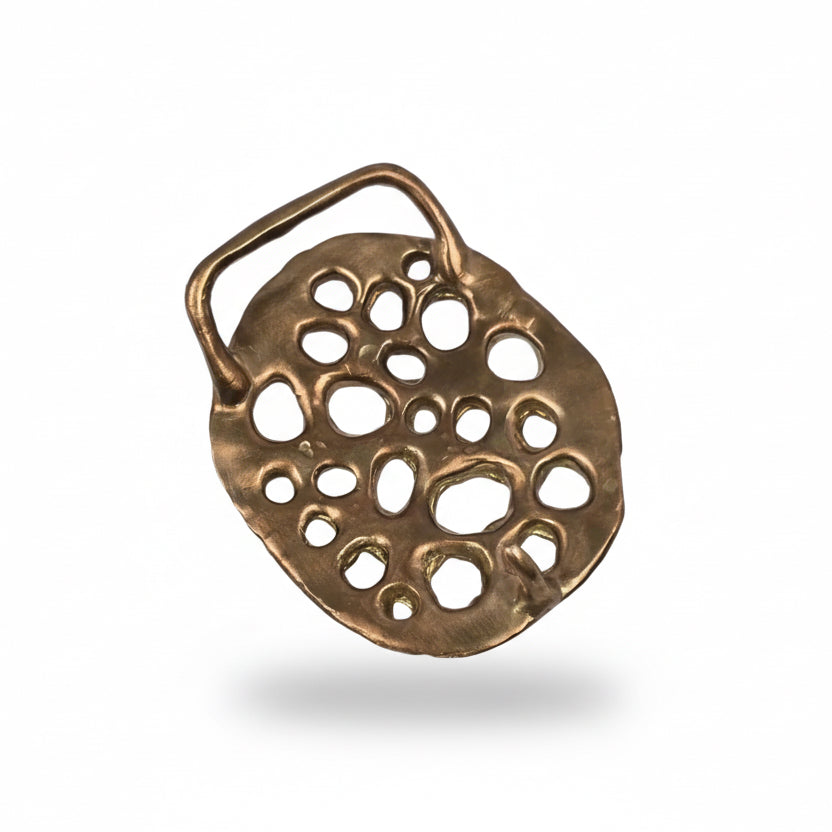 Three-quarter side view of Shaya Durbin's Lotus Belt Buckle showing the dimensional bronze structure, organic cutout pattern and curved sculptural profile.
