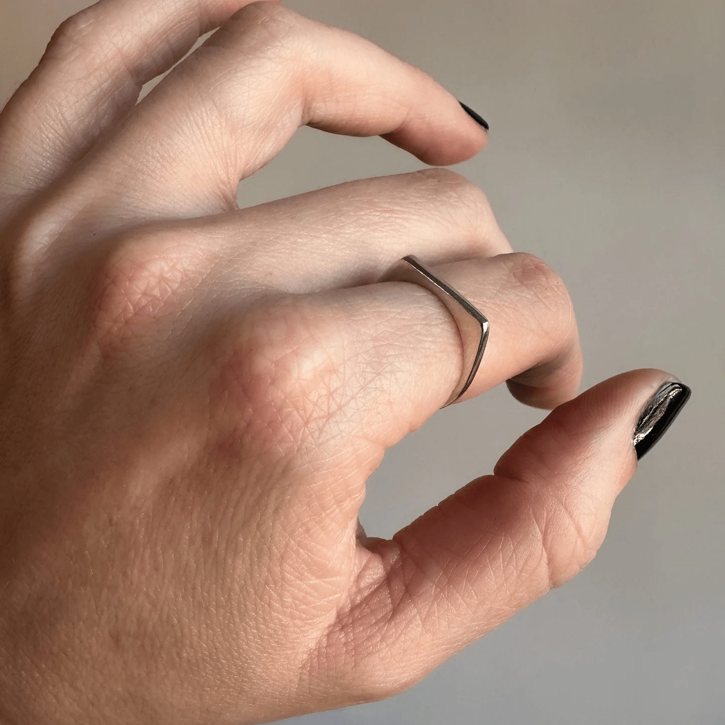 Side view of the sterling silver tapered ring worn on a hand.